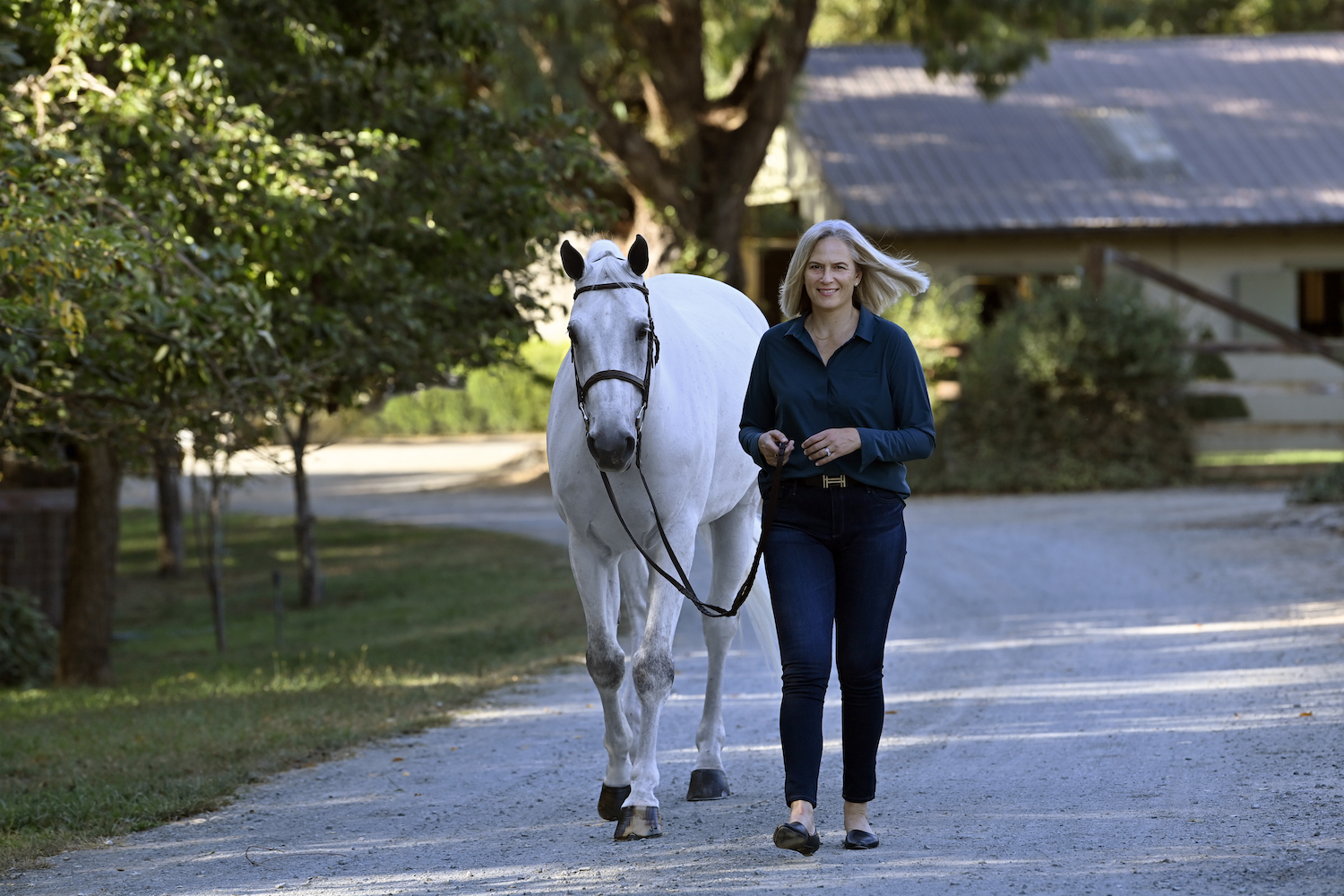 Tonya Johnston walking with a white horse